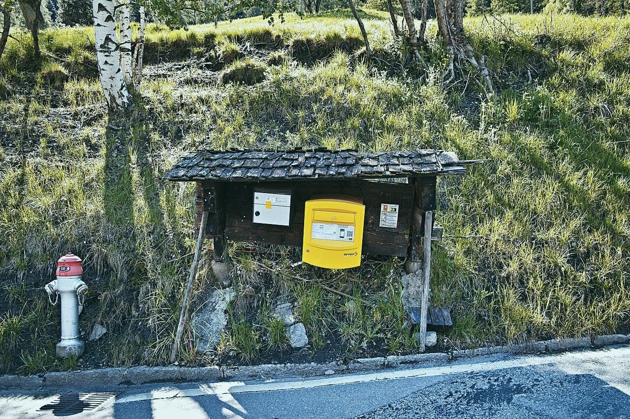 Boîte aux lettres suisse jaune le long d’une route